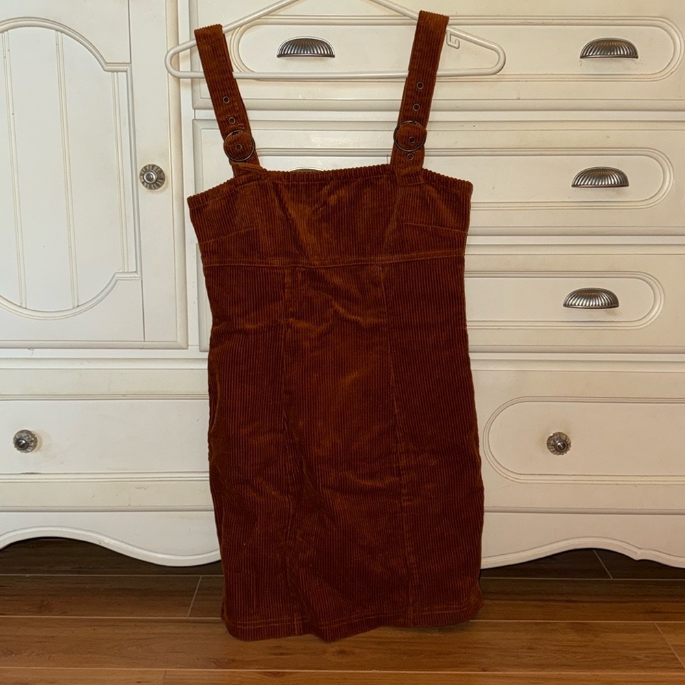 Burnt orange corduroy dress with adjustable buckle straps. And zipper closure